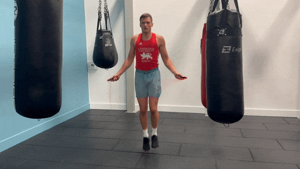 a boxer jump roping to warm up for a heavy bag workout