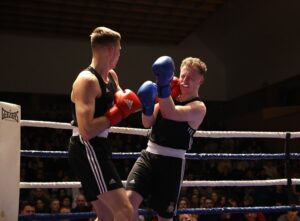 Boxer in ring landing a punch on his opponent