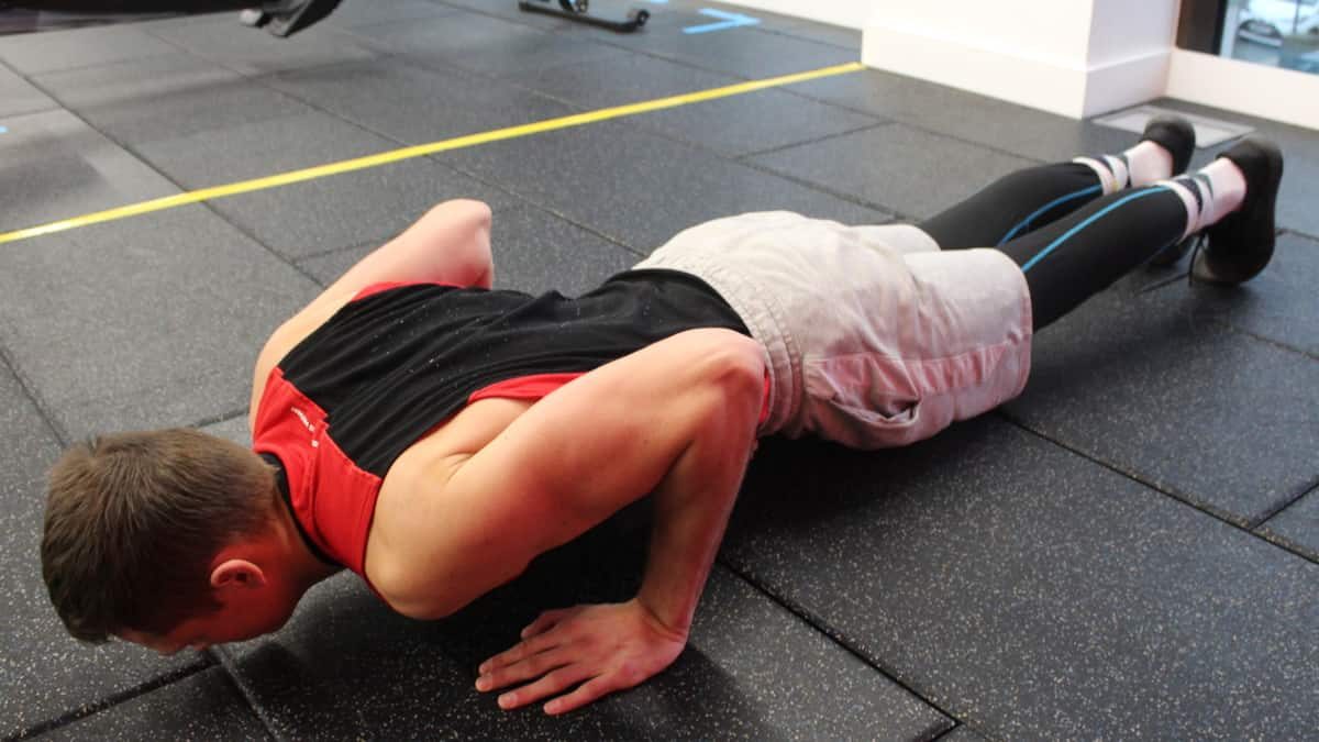 Mike in dipping down during the second step of performing the standard proper pushup form.