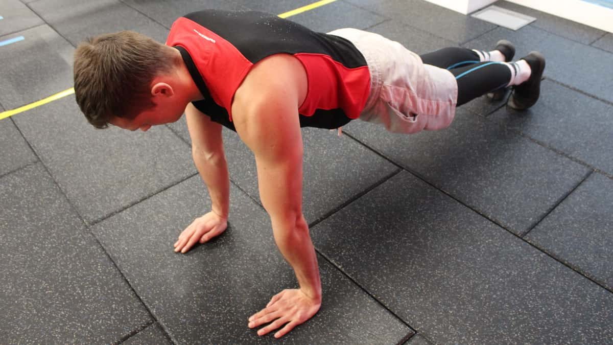 Mike in the plank position during the first step of performing the standard proper pushup form.